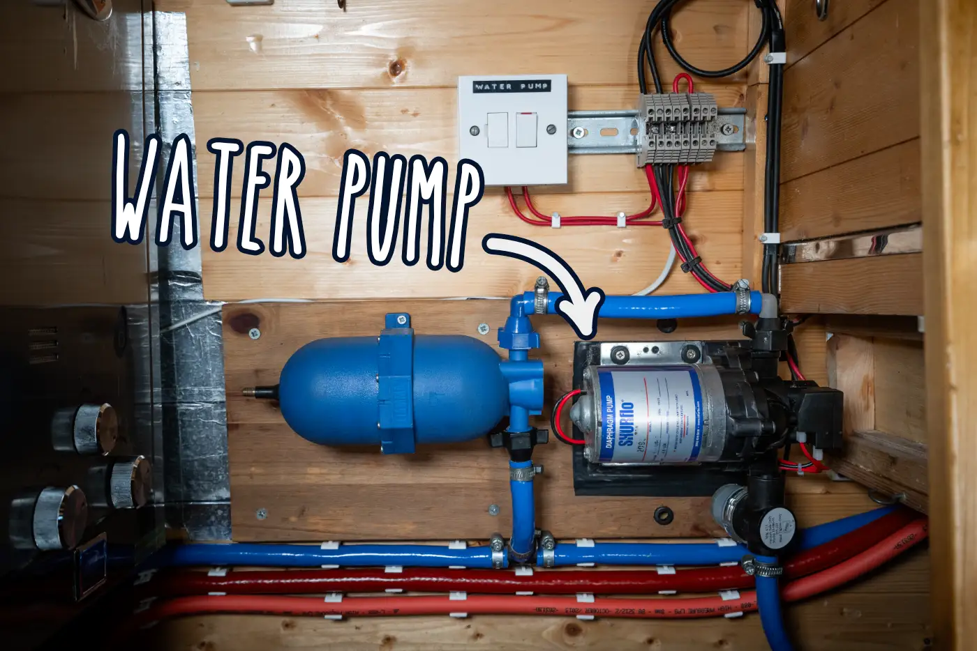 DIY campervan water system installation showing water pump, accumulator, wiring, pipework and water heater